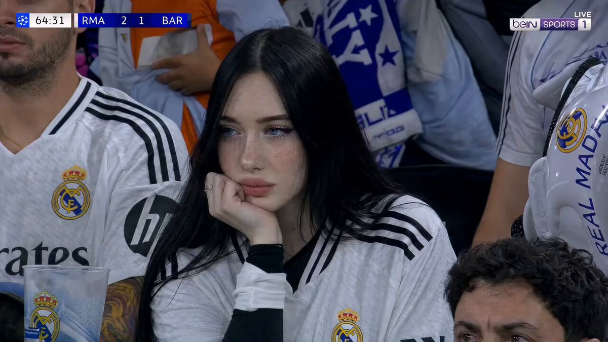Woman sitting in a crowded football stadium