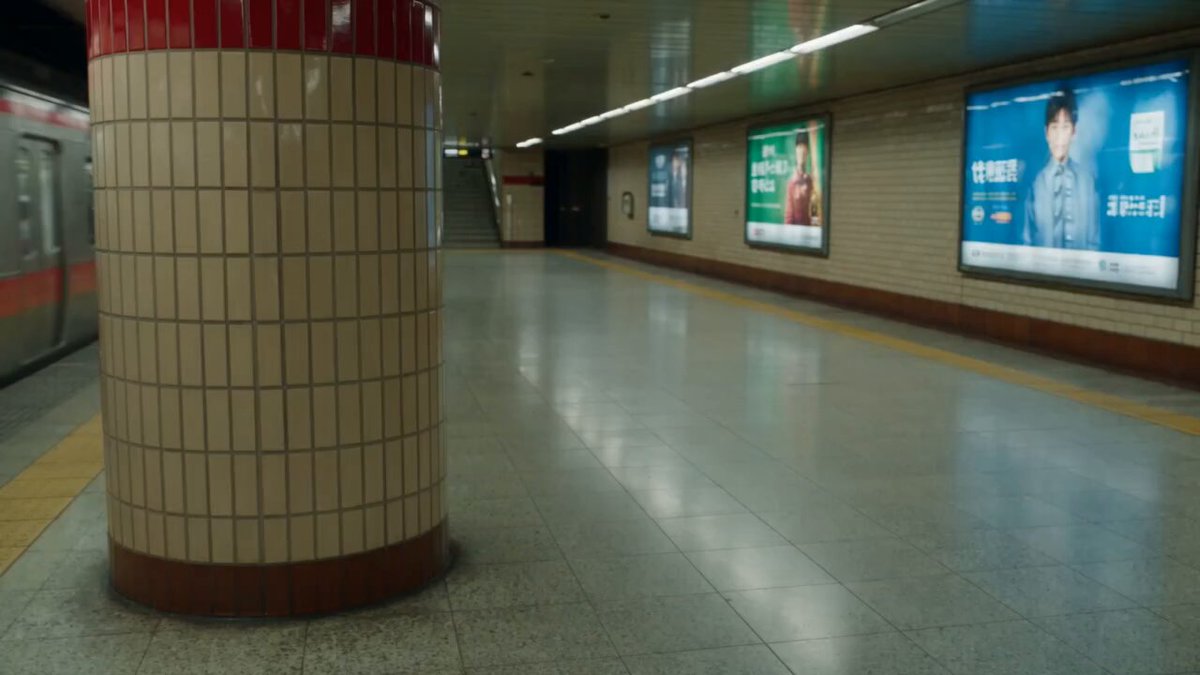 Woman breaking through a subway station pillar