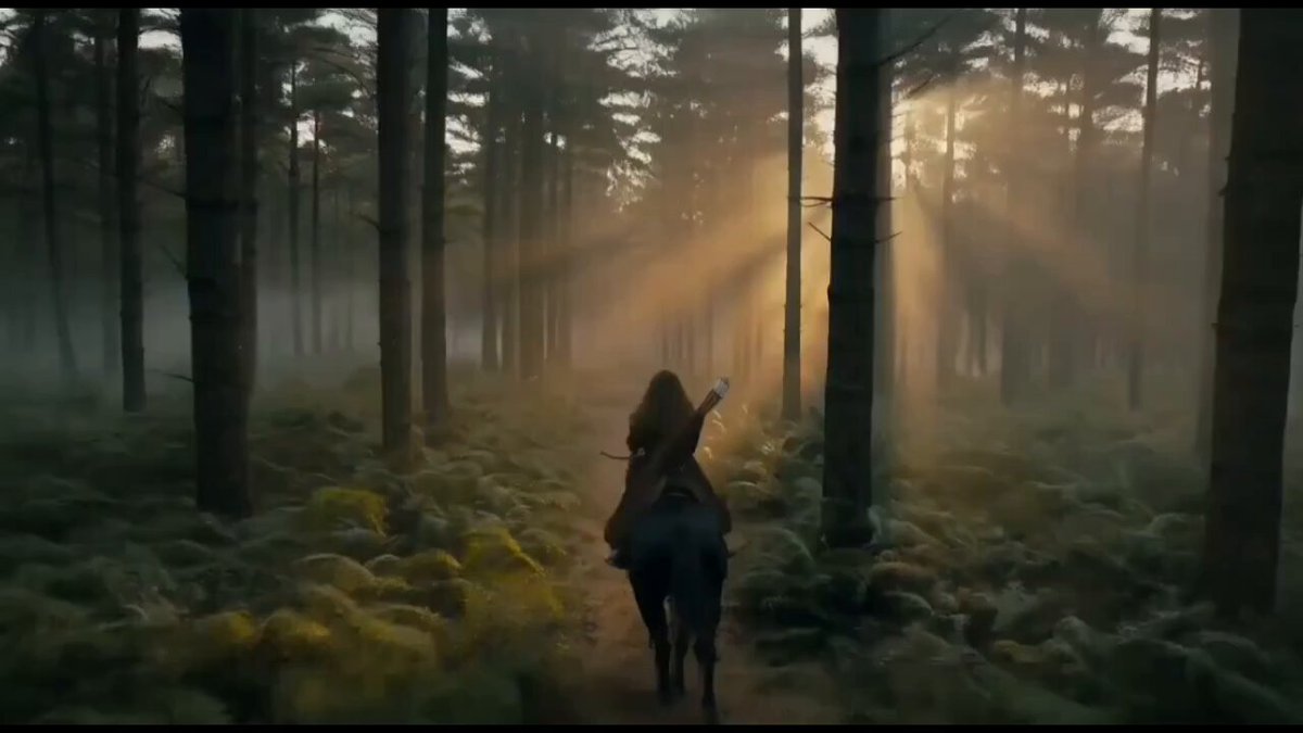Female archer riding through a misty forest